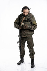 soldier in the studio on a white background. a man in military uniform with a rifle or machine gun. military or airball player