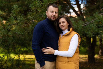 Fototapeta premium happy adult husband and wife in the autumn forest stand embracing