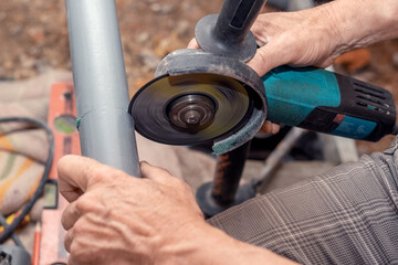 Obraz premium A craftsman cuts a PVC pipe using an x-angle grinder