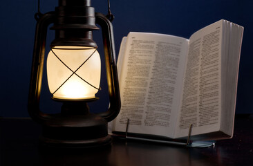 old lamp illuminates book, concept power outages