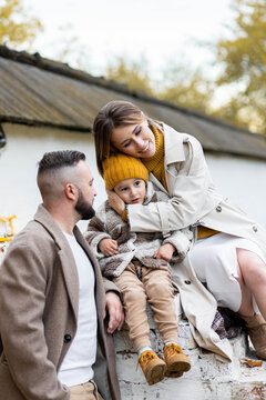 Happy Family On A Beautiful Fall Picnic In The Park. Cozy Autumn Vibes. Young Father, Mother And Their Cute Son Spending Quality Time Together, Having Fun. In The Park