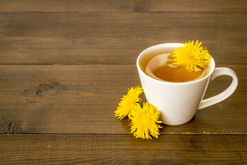 Herbal tea with meadow yellow dandelions blossoms and leaves