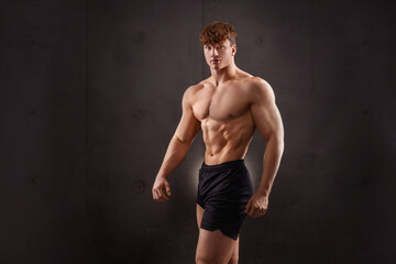  The torso of attractive muscular male body builder on black background.