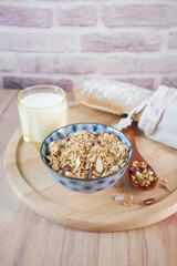 Home Made Musli in a bowl, glass of milk and bread on table 