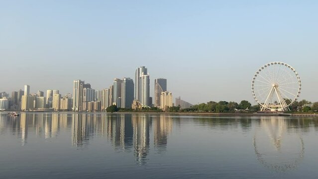 Eye of Emirates, giant wheel, Sharjah Skyline. Morning view of Sharjah's Khalid Lake, UAE