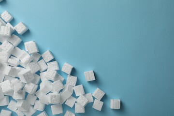 Many styrofoam cubes on light blue background, flat lay. Space for text