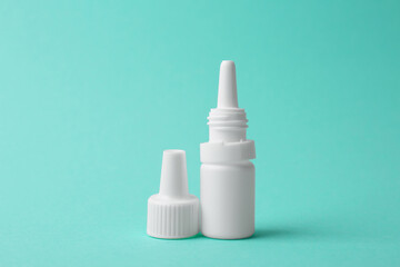 Bottle of medical drops on turquoise background