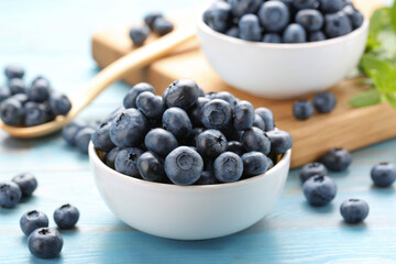 Tasty fresh blueberries on light blue table, closeup