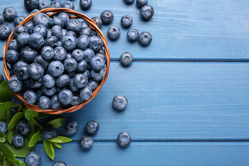 Tasty fresh blueberries on blue wooden table, flat lay. Space for text