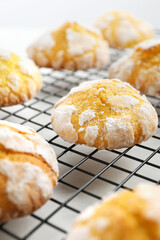Tasty homemade lemon cookies on cooling rack, closeup
