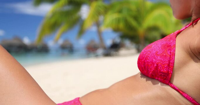 Bikini body. Woman closeup on beach vacation travel enjoying the sun in bikini sunbathing. Sexy slim young adult on woman for tropical travel holidays or diet concept.