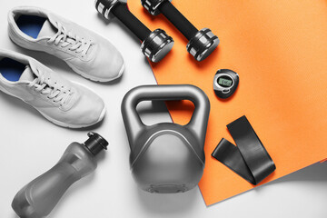 Exercise mat and other sport equipment on white background, flat lay