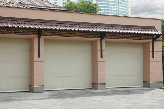 Building With White Sectional Garage Doors On Sunny Day