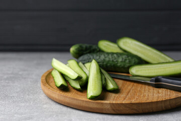 Whole and cut fresh ripe cucumbers on grey table