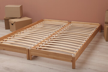 Wooden bed frame and cardboard boxes on floor in room