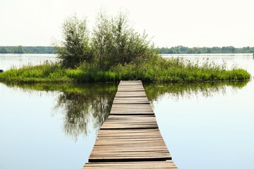Wooden bridge to a small island in the lake