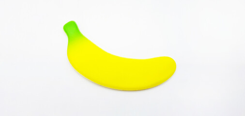 Fake banana isolated on white background. Small toy, shape and object. concept. Not real of fruit