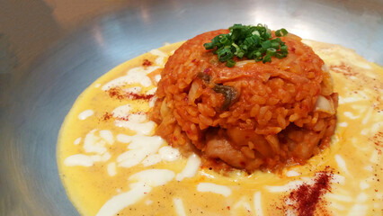 Close up fried kimchi rice with egg and cream cheese sauce on stainless steel plate or dish. Asian and famous food in Korea. 