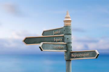 justice equity freedom representation  four word quote written on fancy steel signpost outdoors by the sea. Soft Blue ocean bokeh background. - obrazy, fototapety, plakaty