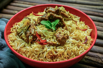 Delicious mutton biryani top view.Biryani rice dish Beautiful Indian rice dish.Delicious spicy chicken biryani in bowl over moody background, it’s a popular Indian and Pakistani food.