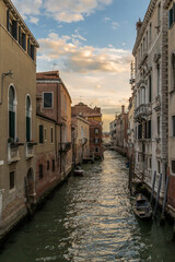 Fototapeta na wymiar Typical Venetian canal, early in the morning. Venice, Italy. The buildings are reflecting on the calm water