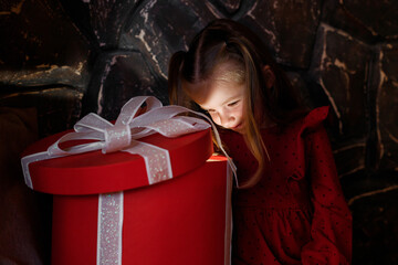 cute little girl peeks into a christmas present