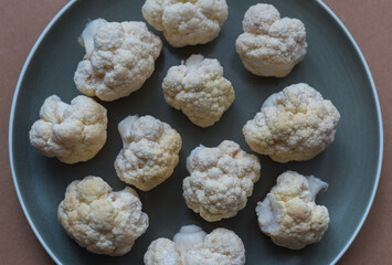 Cauliflower on a plate close-up view from above. Raw cauliflower close-up in a plate.  Broccoli in a plate. The concept of proper nutrition.
