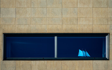 View of a model of a sailing ship behind the window of a stone facade