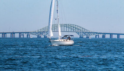 Sailboat passing in front of the Great South Bay Bridge on Long Island