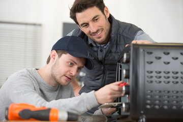 student and teacher repair a computer