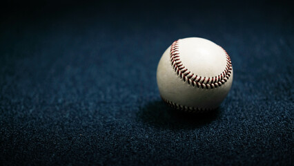 White leather baseball poses on black background.
