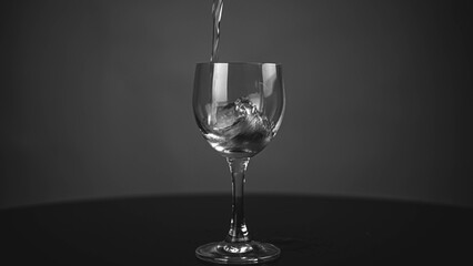 Pour pure drinking water into a glass. a glass with water set on a gray background.