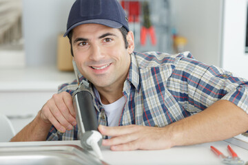 man putting silicone around the sink