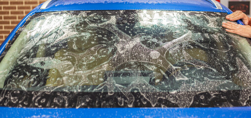The process of installing the PPF on the windshield of a car. PPF is a paint protection film that protects paint from scratches and gravel. Athermal film on the windshield of the car.Car wrapping. 
