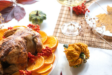 Baked whole chicken or turkey for Christmas. Thanksgiving table with decoration, homemade roasted chicken, wine and salad of fruits, bokeh background