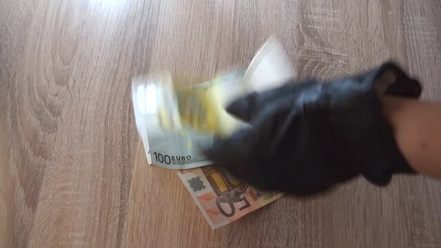 Manos con guante negro cuenta dinero en efectivo