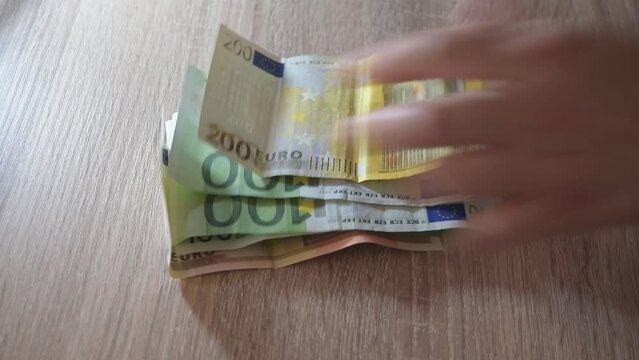 Contar dinero r&aacute;pidamente sobre una mesa. Full HD. Primer plano. Mujer cuenta billetes de euro.