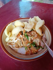 Indonesian Chicken Rice Porridge served with shredded chicken and crackers. Bubur Ayam Indonesia.