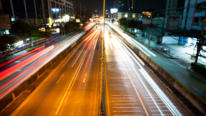 Fototapeta na wymiar The light of cars running against each other with a low shutter shot in the middle of the capital Bangkok Thailand