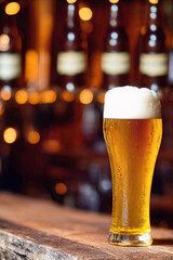 closeup of beer with foam in glass laying on rustic wooden table