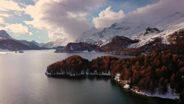 Lake Sils, Switzerland: Stunning aerial drone footage of the snow covered lake Sils in the Engadine valley near Saint Moritz and Silvaplana in the Swiss alps 
