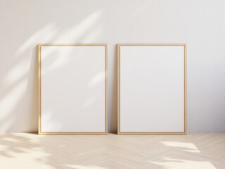 Two blank pictures with wooden frames standing on parquet floor and leaning on white wall. Template for your content. 3D illustration.