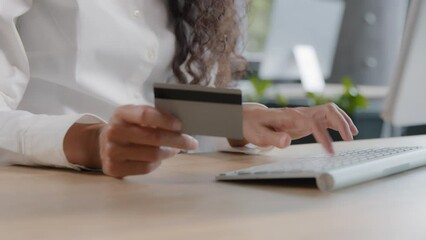 Close-up unrecognizable woman holding credit card enters data in computer typing on keyboard businesswoman makes payment uses banking application for secure payments pays for product in online store