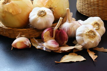 Garlic and onion in a wicker basket on the black surface. Brazilian spices.