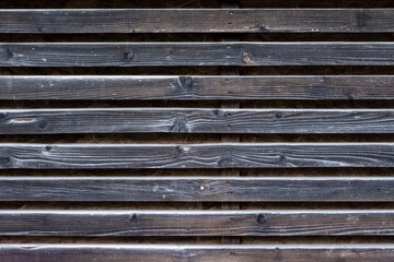 Fragment of a wall made of old wooden weathered slats. For use as an abstract background.