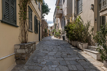 Fototapeta na wymiar Intimate, tranquil and sunlit street located at the foothill of Acropolis, Athens, Greece.