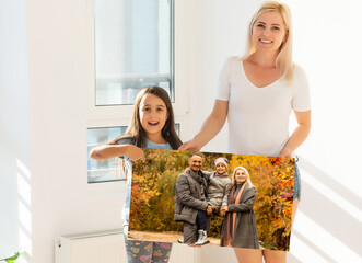 family holding photo canvas with autumn. Beautiful girl with canvas.