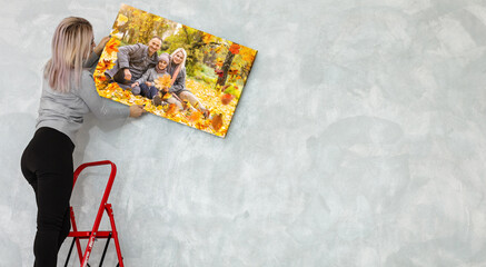 Canvas print with gallery wrap. woman hangs autumn photography, photocanvas