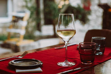 Glass with white wine on the table in restaurant.