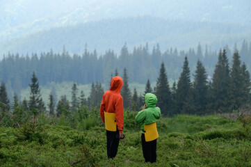 Two boys of school age are hugging and admiring the view of the Carpathians.